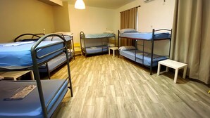 A dormitory room with bunk beds, a small table, and a hanging light fixture. - Cathedral Malaga Hostal - Hostel (Málaga)