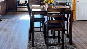 Una cocina con armarios de madera, microondas, horno y ventilador de techo.