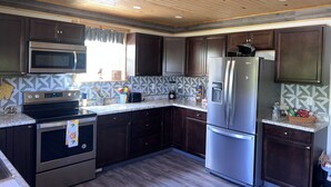 Una cocina moderna con armarios de madera oscura, electrodomésticos de acero inoxidable y un salpicadero con diseño.