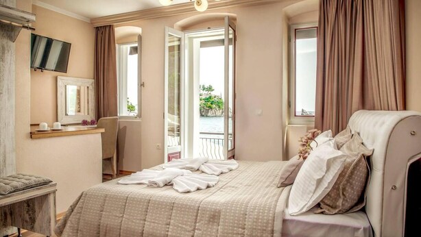 Un dormitorio con cama, escritorio y vistas al exterior.