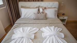 Una cama bien hecha con sábanas y toallas blancas dispuestas en forma de abanico.