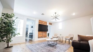 Uma sala de estar moderna com lareira, uma mesa de centro redonda e um sofá de couro.