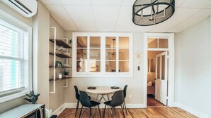 Kompakti keittiö, jossa on ruokailutila, puulattia ja sisäänrakennettu kirjahylly.