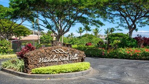 Un panneau indiquant l’emplacement de Waikoloa Beach Villas, avec un jardin aménagé au premier plan.