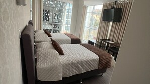 A modern hotel room with a large bed, a flat-screen TV, and a city view. - NOVUM HOTEL (La Paz)