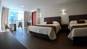 A hotel room with two beds, a desk, and a chair. - NOVUM HOTEL (La Paz)