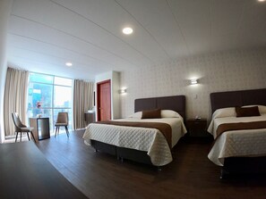 A hotel room with two beds, a desk, and a chair. - NOVUM HOTEL (La Paz)