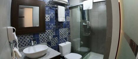 A bathroom with a sink, toilet, and shower.
