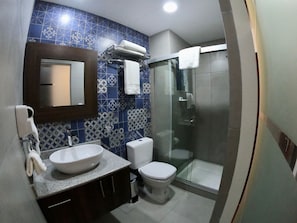 A bathroom with a sink, toilet, and shower.