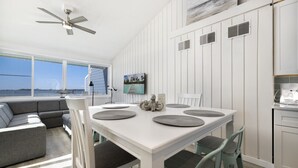 Une cuisine moderne avec une table blanche, des chaises grises et un ventilateur de plafond.