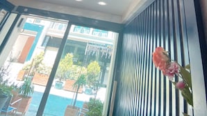 A hotel room with a view of an outdoor swimming pool, ceiling lights, and a potted plant. - BALPETEK HOTEL (Istanbul)