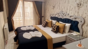 A bedroom with a large bed, a bedside table, a nightstand, and a wardrobe. - BALPETEK HOTEL (Istanbul)