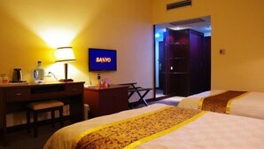 A hotel room with two beds, a desk with a lamp, a television, and a wardrobe. - Xintiandi Hotel (Haiyan)