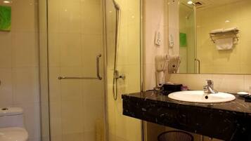 Un baño con ducha de vidrio, un lavamanos blanco y un espejo.