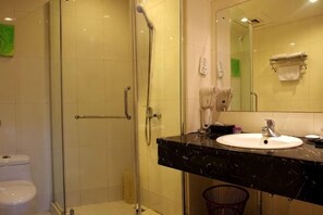 A bathroom with a glass-enclosed shower, a white sink, and a mirror. - Xintiandi Hotel (Haiyan)