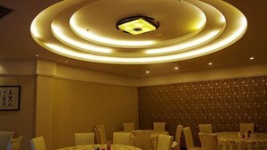 A conference room with a circular ceiling design, multiple tables, and chairs. - Xintiandi Hotel (Haiyan)