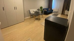 Un espacio habitable compacto con comedor, sofá y televisor.