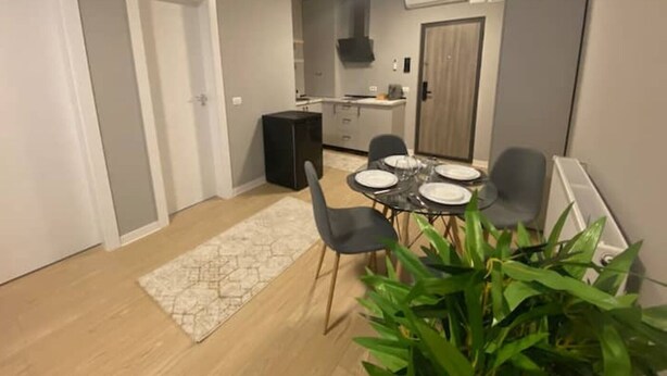 Un espacio habitable compacto con comedor, kitchenette y una pequeña oficina.