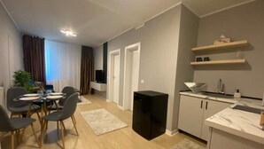 Un apartamento moderno con comedor, cocina y una pequeña sala de estar.