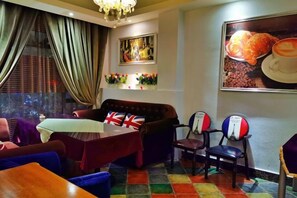 A dining area with a table, chairs, and a view of the city. - Aishang Hotel (Pubei Maoyuan Diwang International) (Pubei)