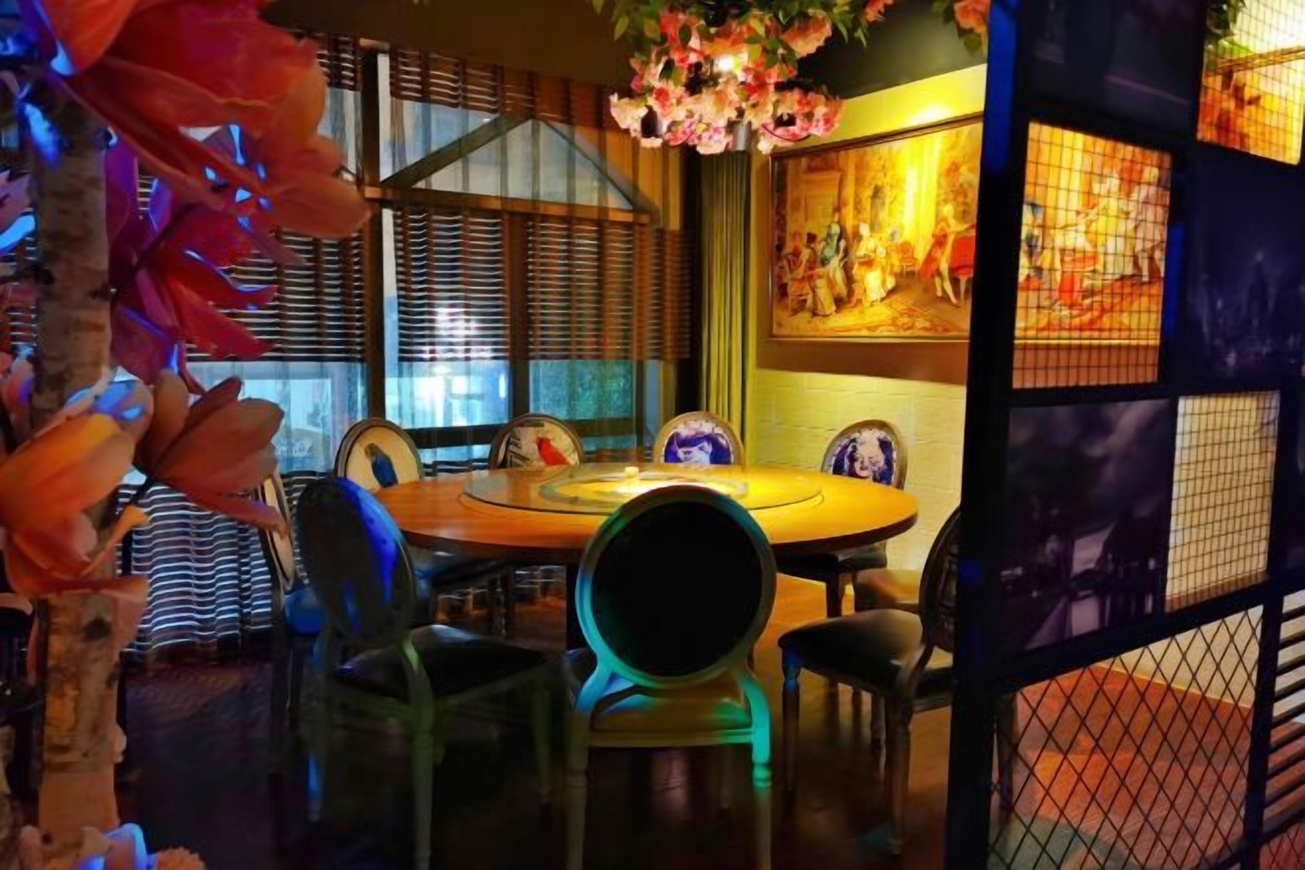 A dining area with a round table, chairs, and a decorative centerpiece.