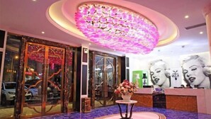 A lobby with a large floral chandelier, a reception desk, and a glass door entrance. - Aishang Hotel (Pubei Maoyuan Diwang International) (Pubei)
