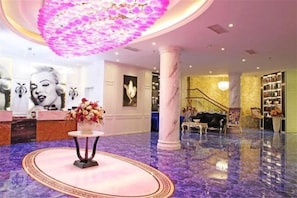 A lobby with a reception desk, a staircase, and a chandelier. - Aishang Hotel (Pubei Maoyuan Diwang International) (Pubei)