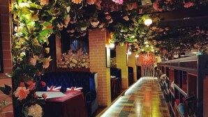 A restaurant with a long, colorful tiled floor, brick walls, and floral decorations on the ceiling. - Aishang Hotel (Pubei Maoyuan Diwang International) (Pubei)