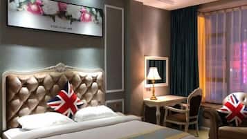 A hotel room with a large bed, a desk, and a chair. There is a painting on the wall and a window with curtains.