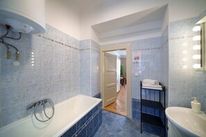 A modern bathroom with a bathtub, a sink, and a vanity mirror. - OLD TOWN-3 BEDROOM 3 BATHROOM TEMPLOVA (Hlavní mesto Praha)