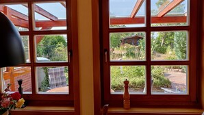 Una stanza con ampie finestre, un tavolo di legno e una sedia.