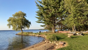 A lakeside park with a wooden deck, picnic tables, and a hammock. - 4 seasons of adventures on Indian Lake/Sunset View Resort/Unit#4 (Manistique)