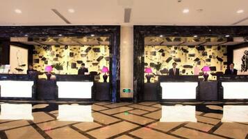 A reception area with two counters, a patterned wall, and a tiled floor.
