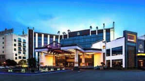 Ein modernes Hotel mit einem markanten Eingang, großen Fenstern und einer gut beleuchteten Fassade.