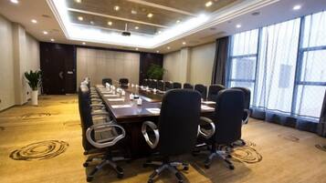 A conference room with a long table, chairs, and a projector.