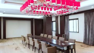 A conference room with a long table, chairs, and a modern chandelier.