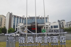 L’entrée d’un hôtel, avec une enseigne indiquant le nom « HUIFENGWANYUN HOTEL HUHANG SHAN ».