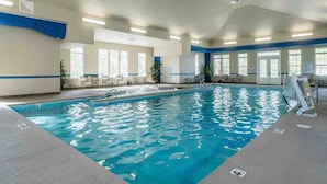 An indoor swimming pool with clear water, surrounded by windows and chairs. - TPV - Antilia - Luxury w/Indoor Heated Pool & Gym (Durham)
