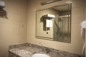 Casa de banho com lavatório, espelho e secador de cabelo.