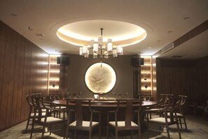 A round dining table with chairs, a chandelier, and wall sconces. - Junrui Garden Hotel (Qianguo)