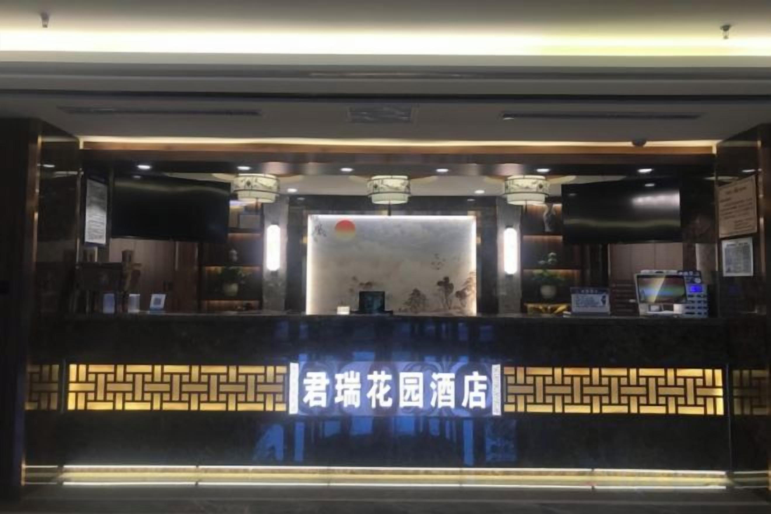 Un'area di accoglienza dal design moderno, con una reception, un display digitale e una parete decorativa.