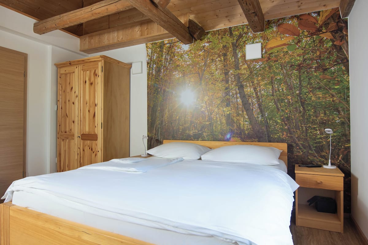 Une chambre à coucher avec un lit en bois, une table de chevet avec une lampe et une armoire.