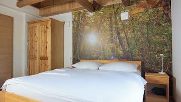 A bedroom with a wooden bed, a nightstand with a lamp, and a wardrobe.