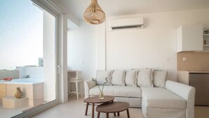 Een moderne woonkamer met een witte bank, een houten salontafel en een hanglamp.