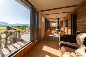 A log cabin with a wooden deck and a view of mountains. - East Glacier Cabin w/ Stunning Views of the Rockies! 30 min from 2 GNP entrances (Browning)