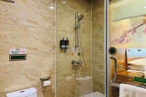 A bathroom with a glass shower enclosure, a toilet, and a sink. - Vienna International Hotel (Daxin Detian Square) (Daxin)