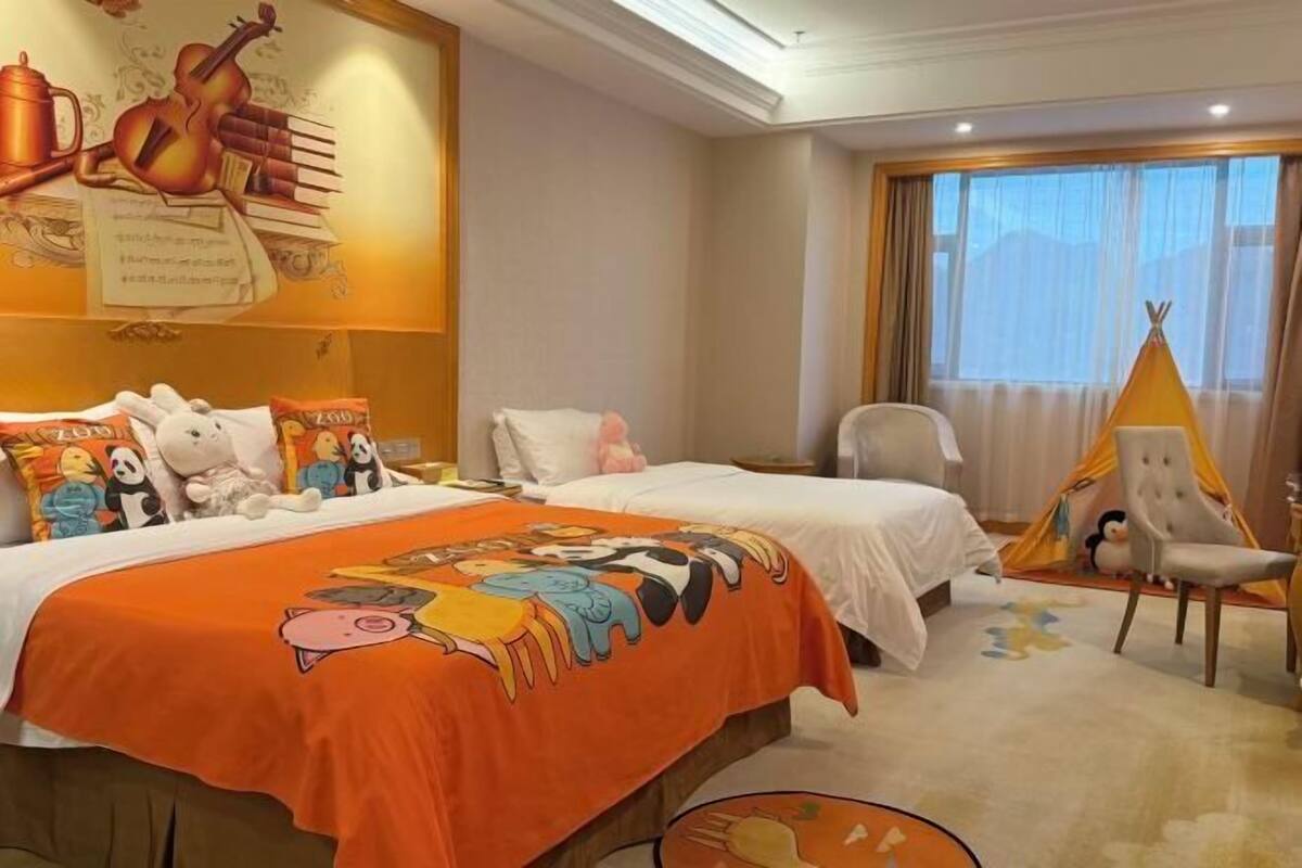 A hotel room with two beds, a large mural on the wall, a teepee, and a chair.