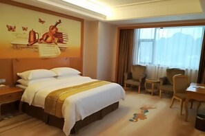 A hotel room with a large bed, a desk, a chair, and a window with curtains. - Vienna International Hotel (Daxin Detian Square) (Daxin)