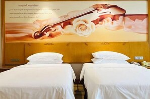 A hotel room with two beds, a wooden headboard, and a large wall mural of a violin and roses. - Vienna International Hotel (Daxin Detian Square) (Daxin)
