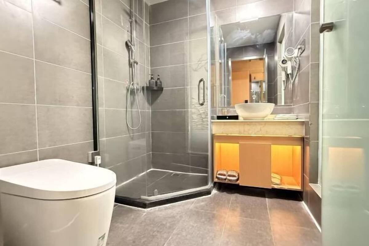 A modern bathroom with a shower, toilet, and vanity.